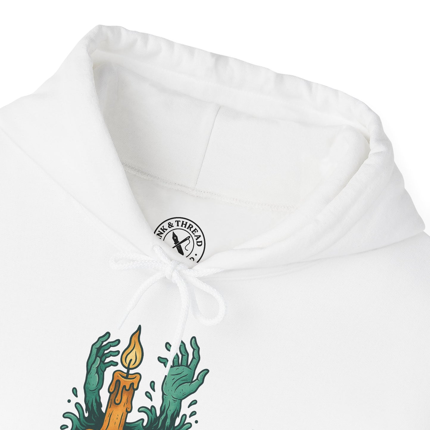 White hoodie with green hands holding a candle design and a logo on the chest.