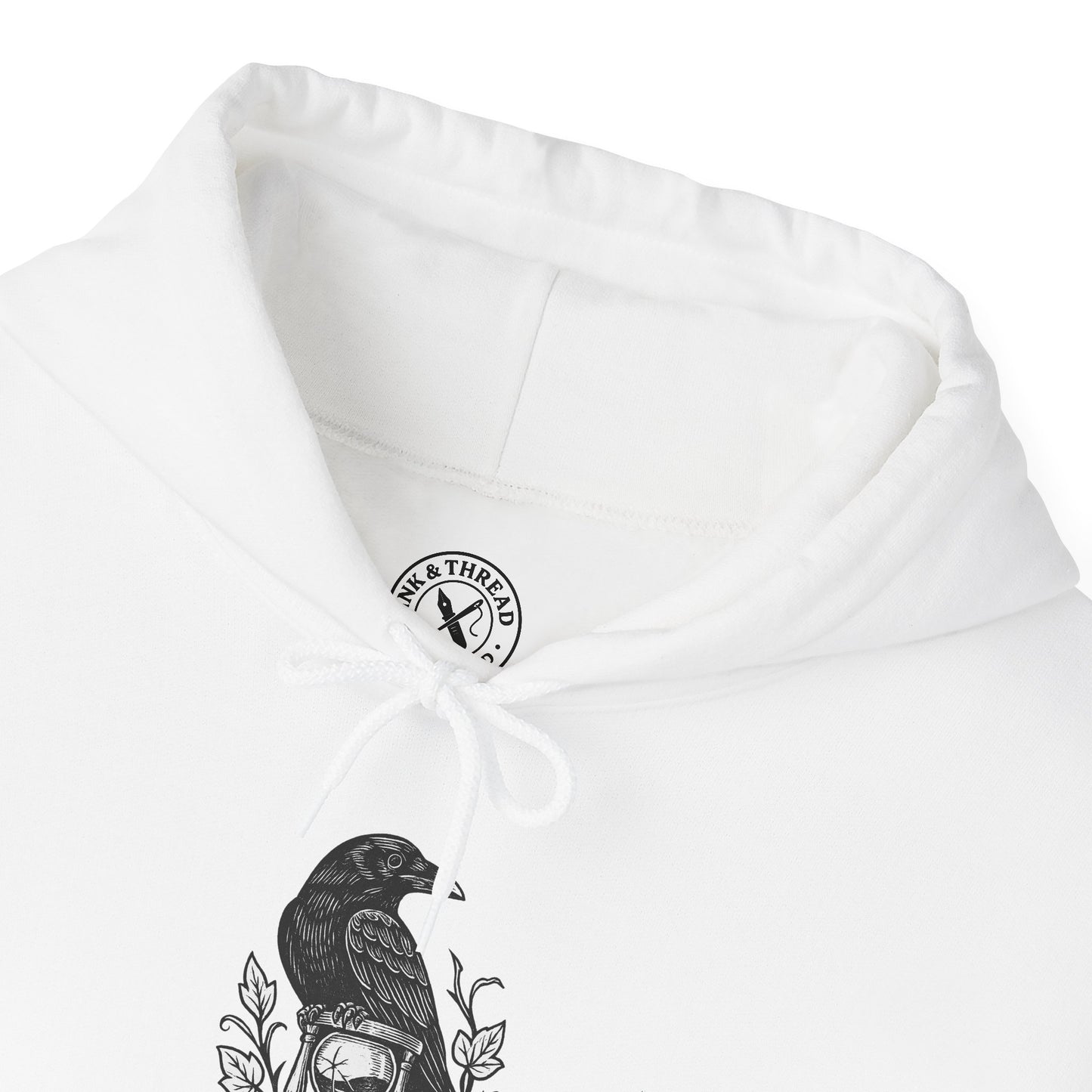 White hoodie with a brand logo on the chest and a bird design on the sleeve.