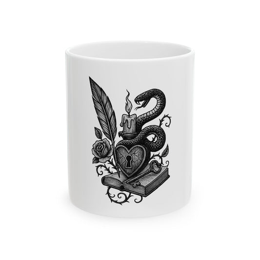 White mug with black decorative design featuring a snake, heart, and book on a white background