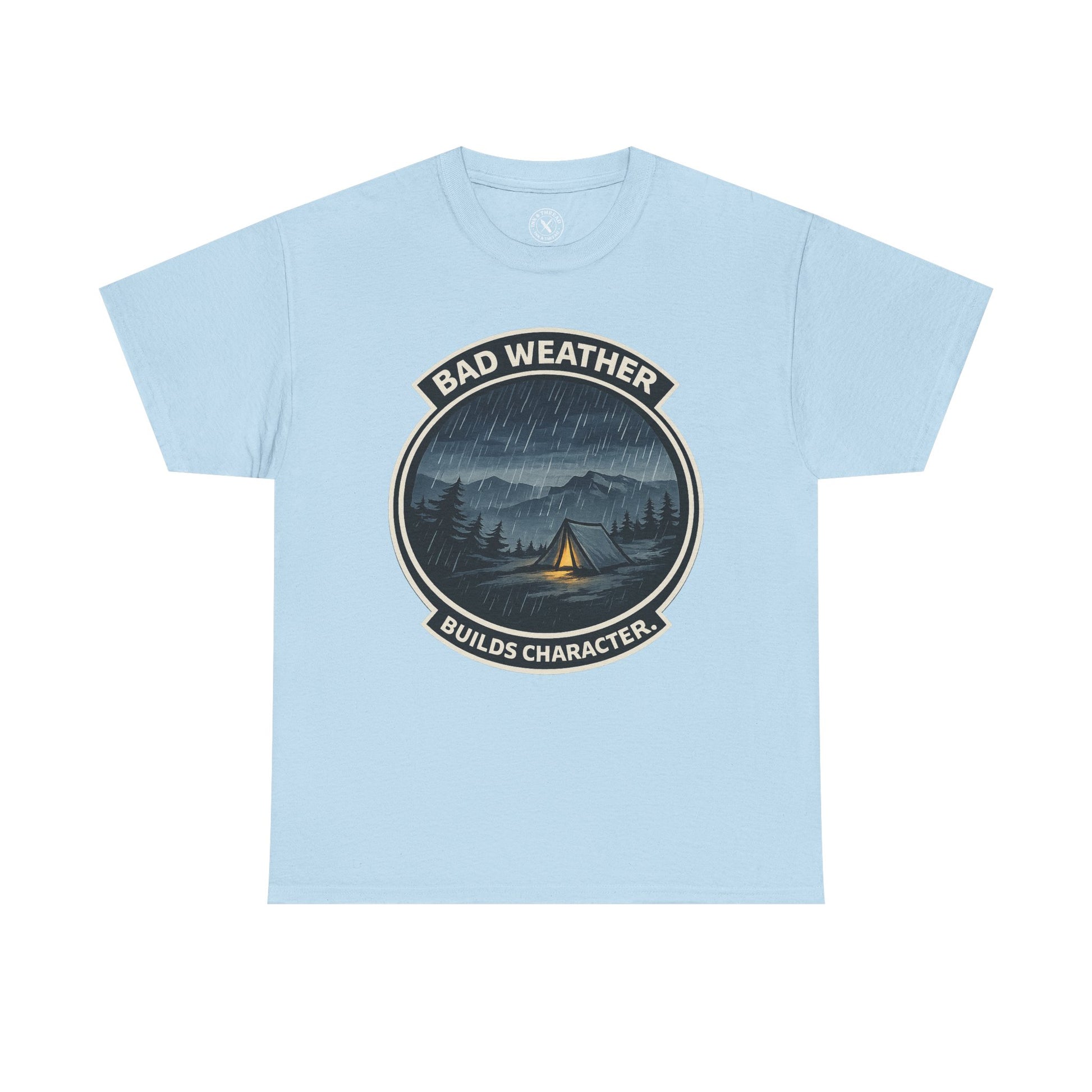 Light blue unisex t-shirt featuring Bad Weather Builds Character camping badge graphic with rainy tent scene and mountain design