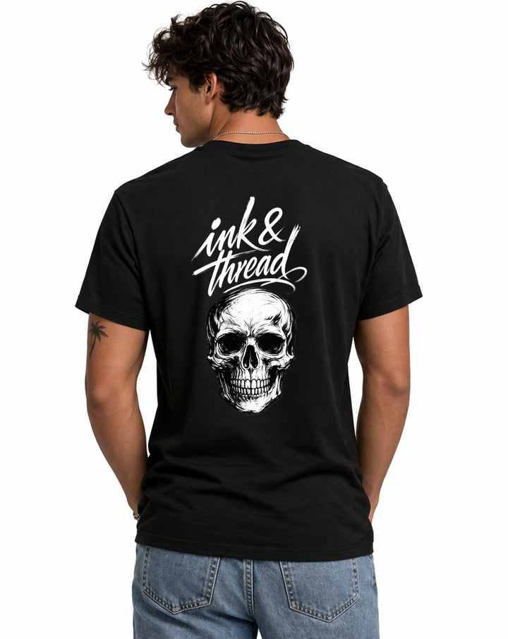 Male model wearing Ink & Thread UK black t-shirt from the back showing script logo and skull graphic