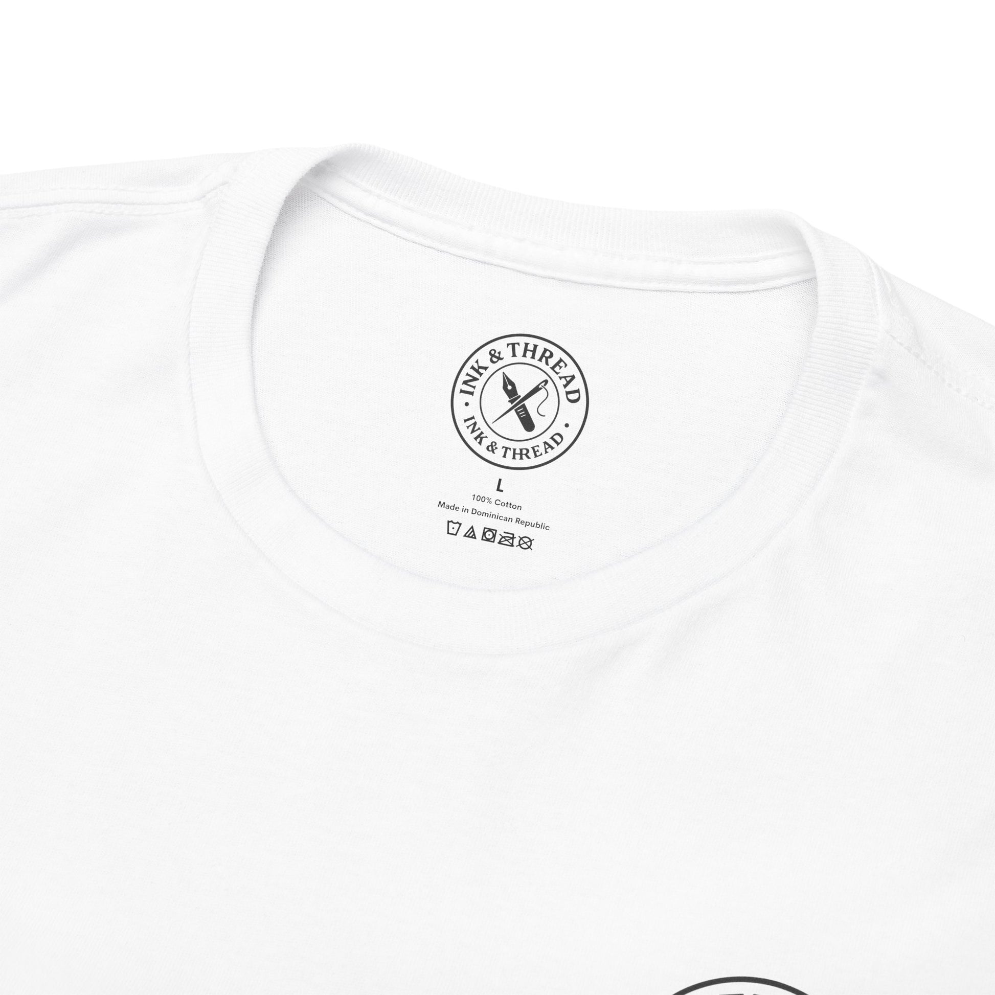 Close-up of Ink & Thread UK branded neck label on white t-shirt showing size tag and care instructions – quality premium graphic tee detail