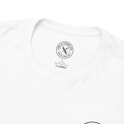 Close-up of Ink & Thread UK branded neck label on white t-shirt showing size tag and care instructions – quality premium graphic tee detail