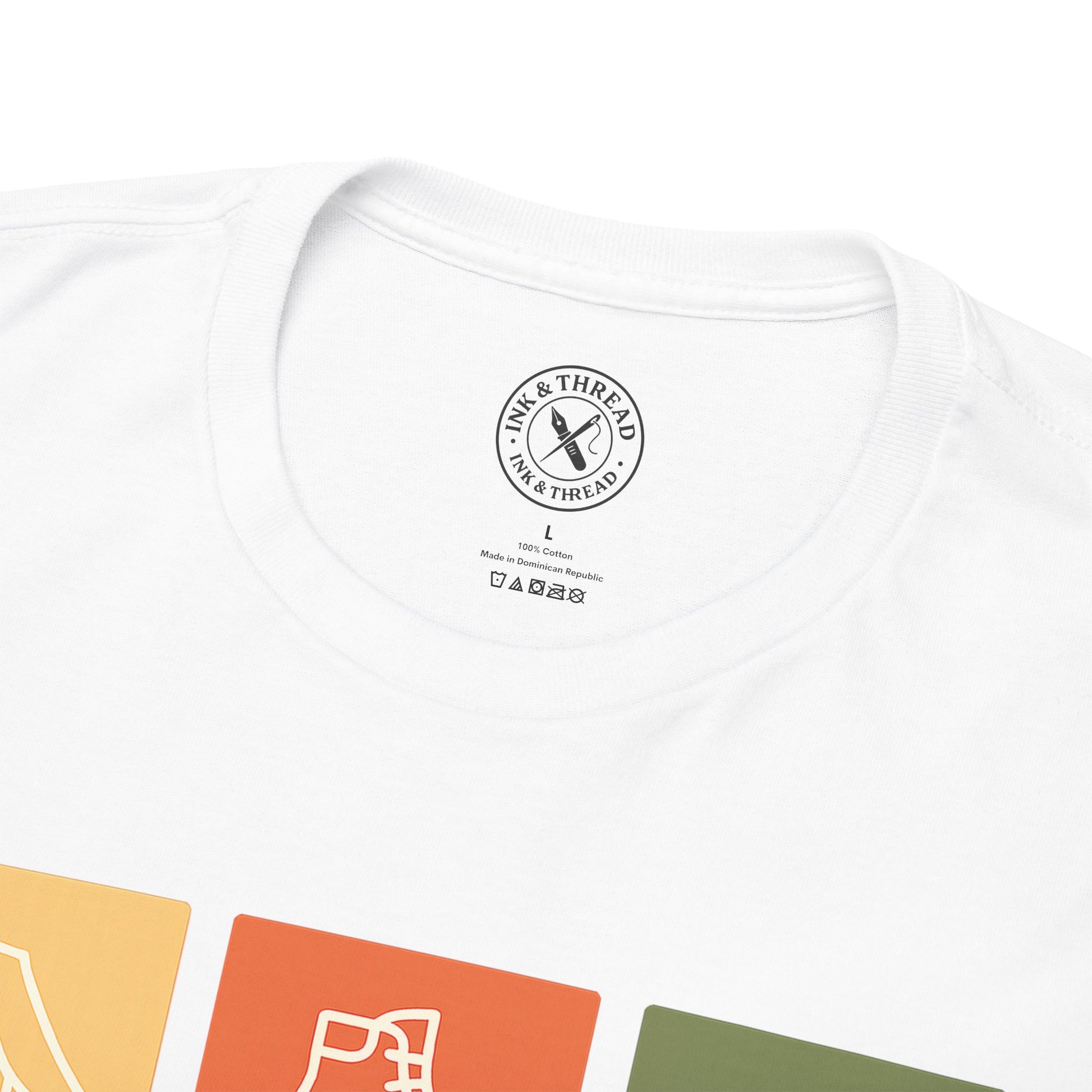 Close-up of Ink and Thread UK inner neck label on white t-shirt showing brand stamp size and care instructions with colour swatches below
