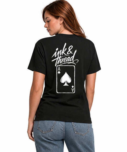 Woman model wearing Ink & Thread UK black t-shirt from the back showing script logo and ace of spades card design