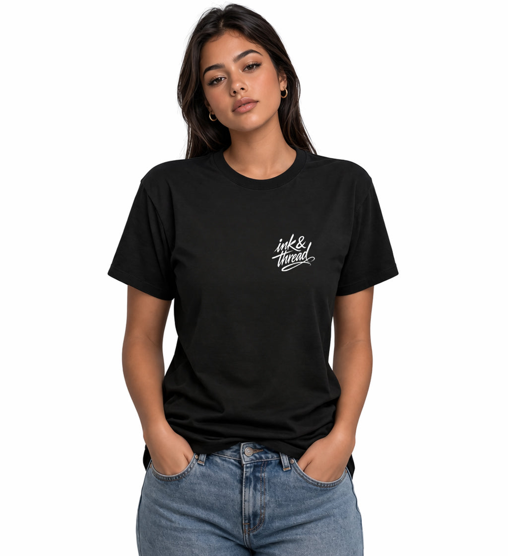 Woman model wearing Ink & Thread UK black t-shirt from the front with script logo on chest and dice design