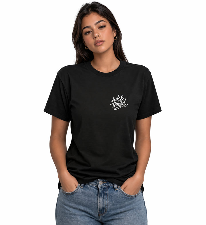 Woman model wearing Ink & Thread UK black t-shirt from the front with script logo on chest and dice design