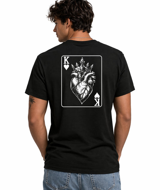 Male model showing back of black t-shirt with King of Hearts playing card design featuring crowned anatomical heart illustration