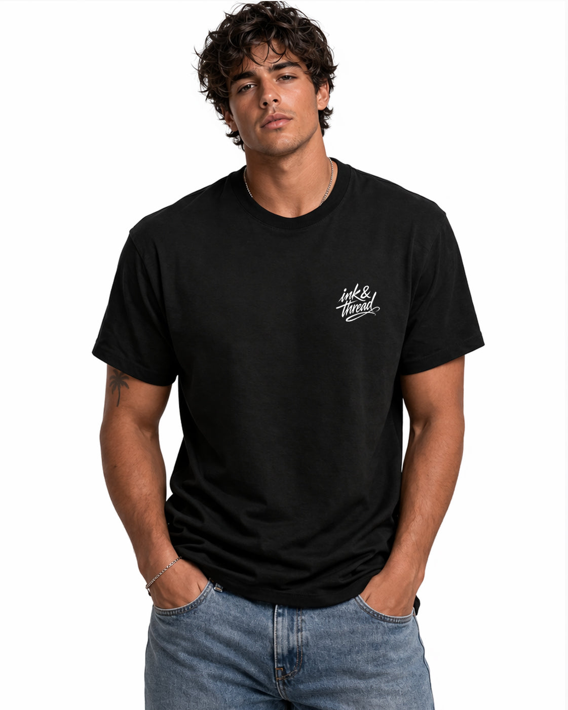 Male model wearing black t-shirt with Ink and Thread script logo on left chest against white background