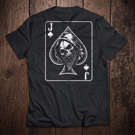 Black t-shirt flat lay on wooden surface with Jack of Spades playing card design featuring skull and grim reaper illustration