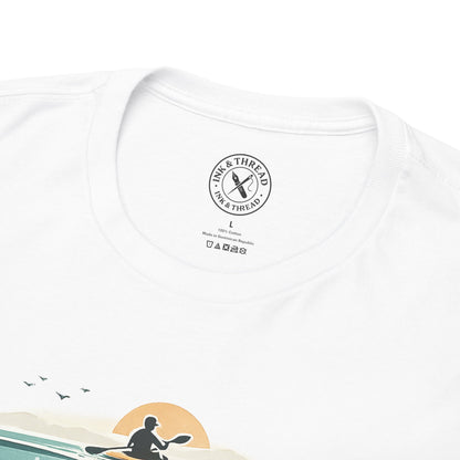Close-up of Ink and Thread UK neck label on white t-shirt featuring kayaking sunset graphic design, showing care label and brand tag