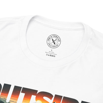 Close-up of Ink and Thread UK neck label on white t-shirt featuring Outside sunset mountain graphic design, showing care label and brand tag