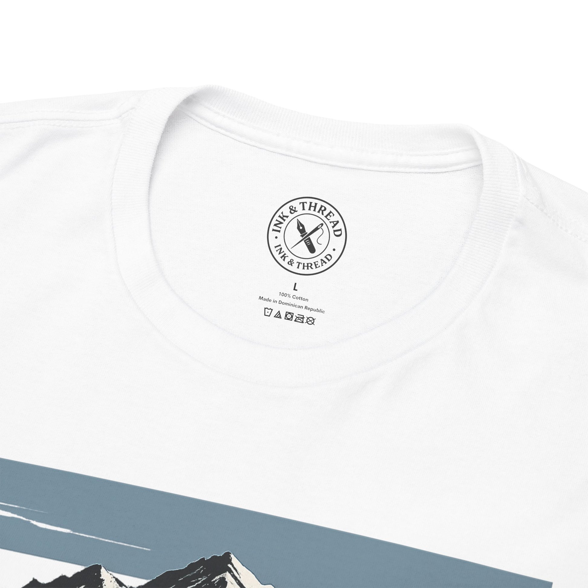 Close-up of Ink and Thread UK branded inner neck label on white t-shirt with Push Higher mountain graphic design