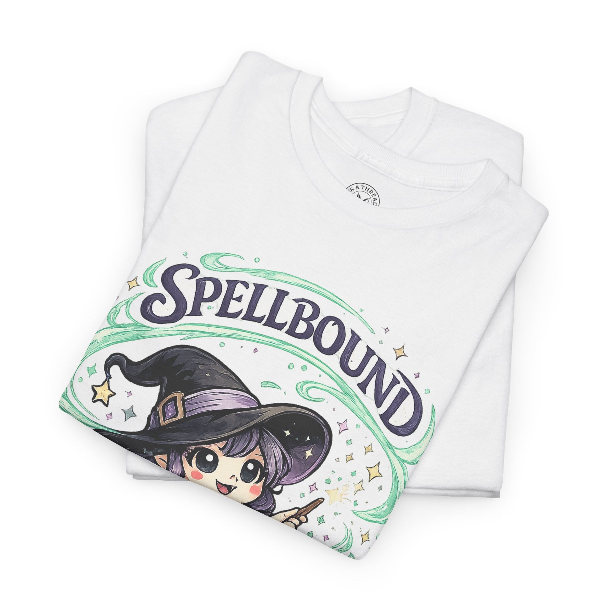 Spellbound white graphic t-shirt folded showing cute anime witch with purple hat and green swirl design
